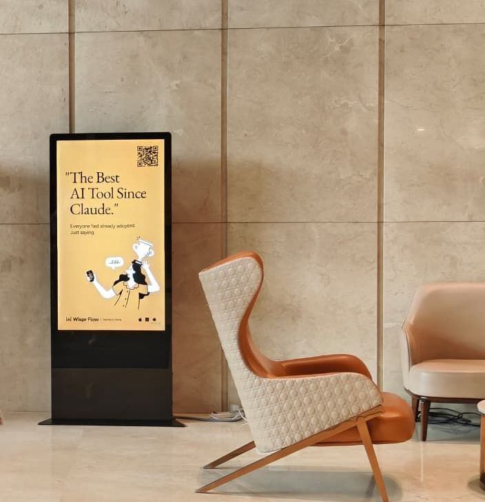 Digital standee showing a Wispr Flow ad in a tech park lobby
